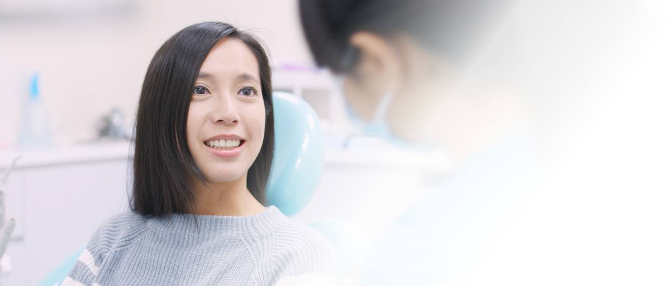 Woman in dental chair listening to her dentist