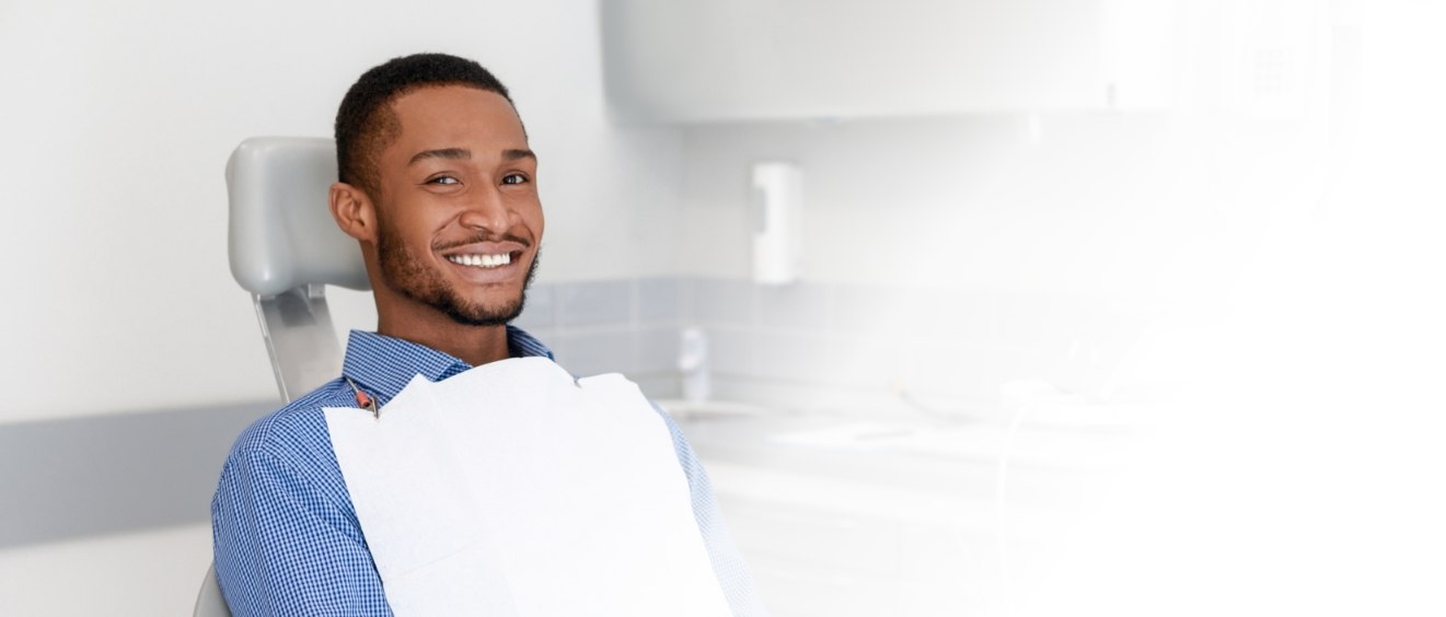 Man smiling in dental chair before treatment