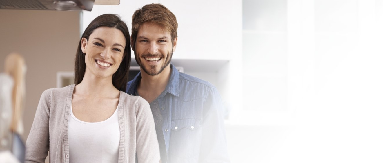 Young man and woman smiling after receiving periodontal services in Vista