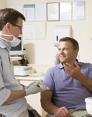 Smiling man in dental chair talking to dentist