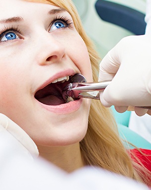 Woman having tooth removed