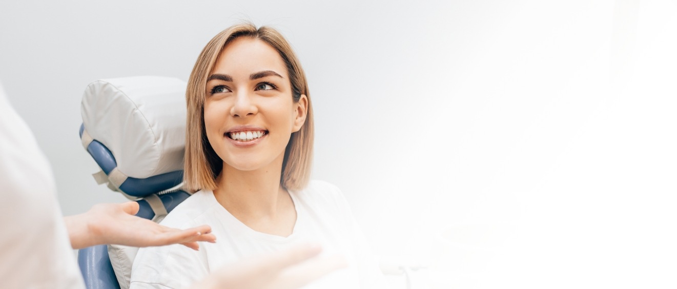 Woman in dental chair listening to her dentist