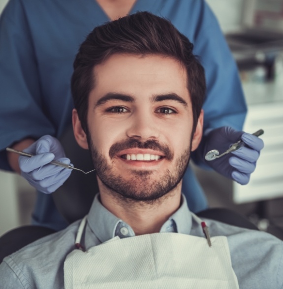 Man with short beard smiling in dental chair