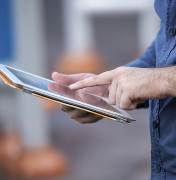 Dental team member swiping on a tablet screen