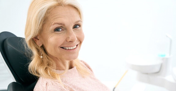 a patient smiling after undergoing dental implant treatment