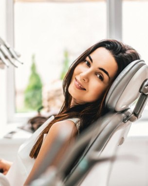 Smiling patient reclining in dental treatment chair