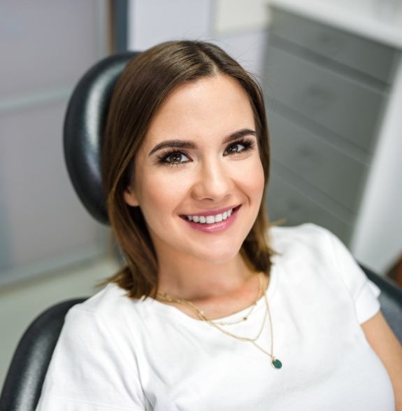 Smiling young woman sitting in dental chair