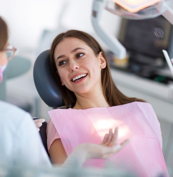 Woman in dental chair talking to her dentist