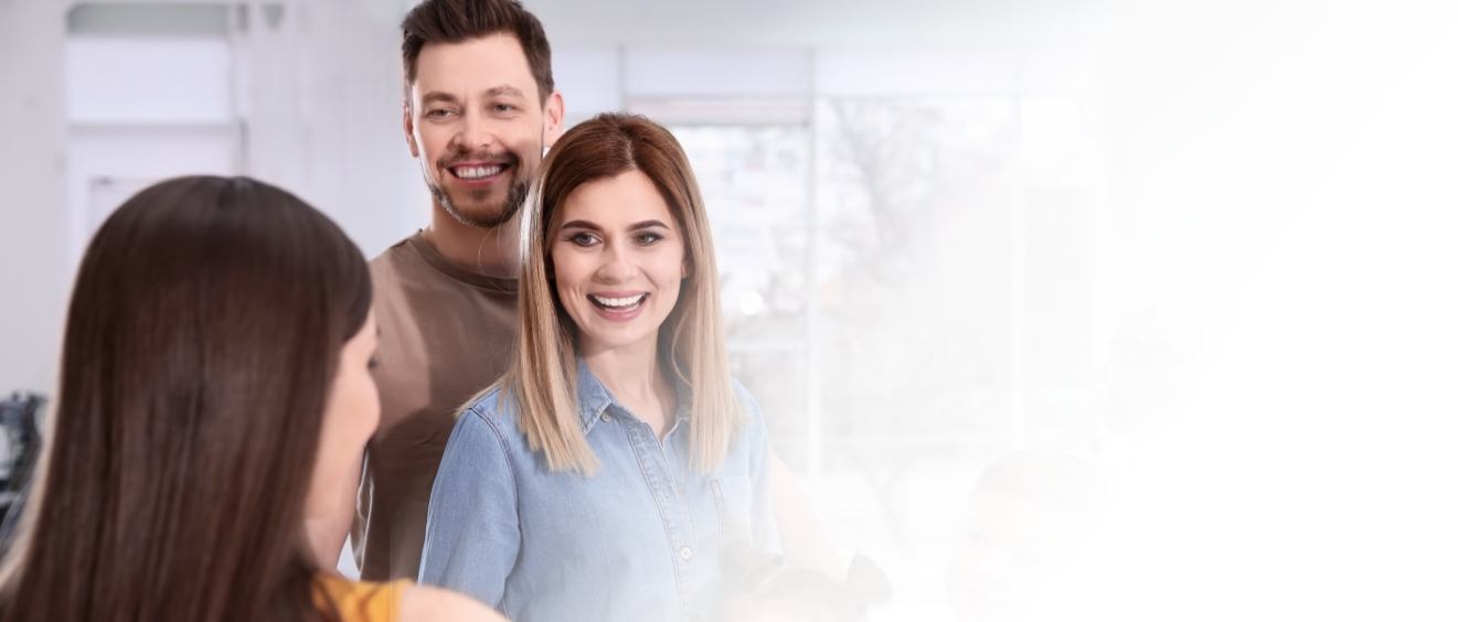 Couple talking to receptionist in periodontal office in Vista