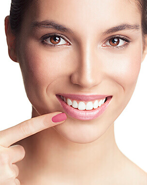 Woman pointing to smile after soft tissue grafting