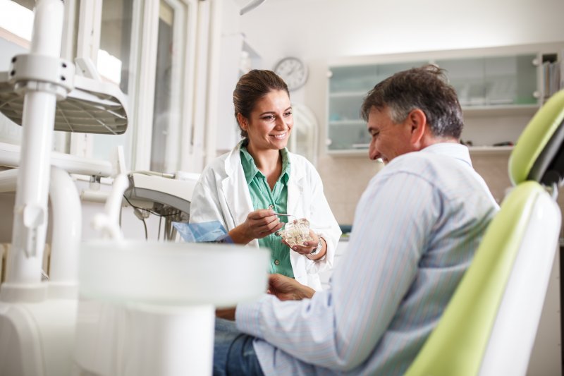 A periodontist talking with her patient about gum disease treatment